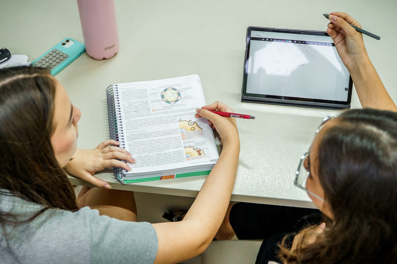 Professora parceira auxiliando aluna nos estudos