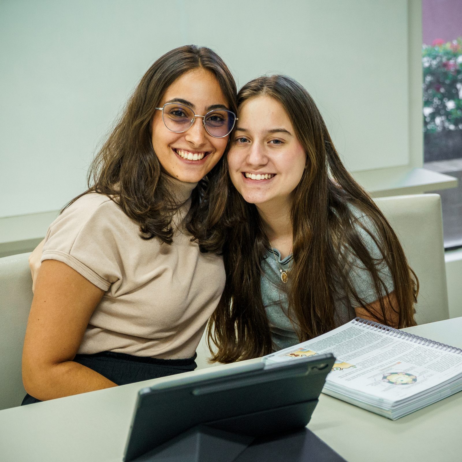 Professora parceira e aluna sorrindo, ambiente acolhedor